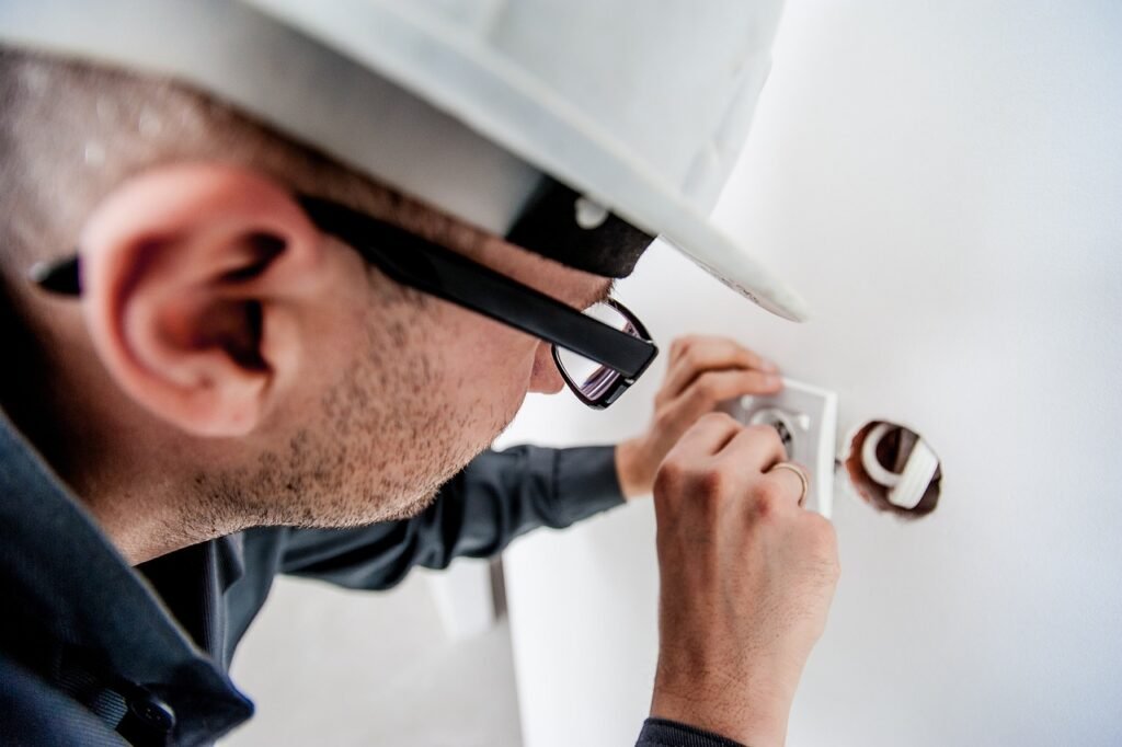 Now Air Conditioning HVAC Services in Wellington, FL and Surrounding areas. A man wearing a hard hat repairing a wall.