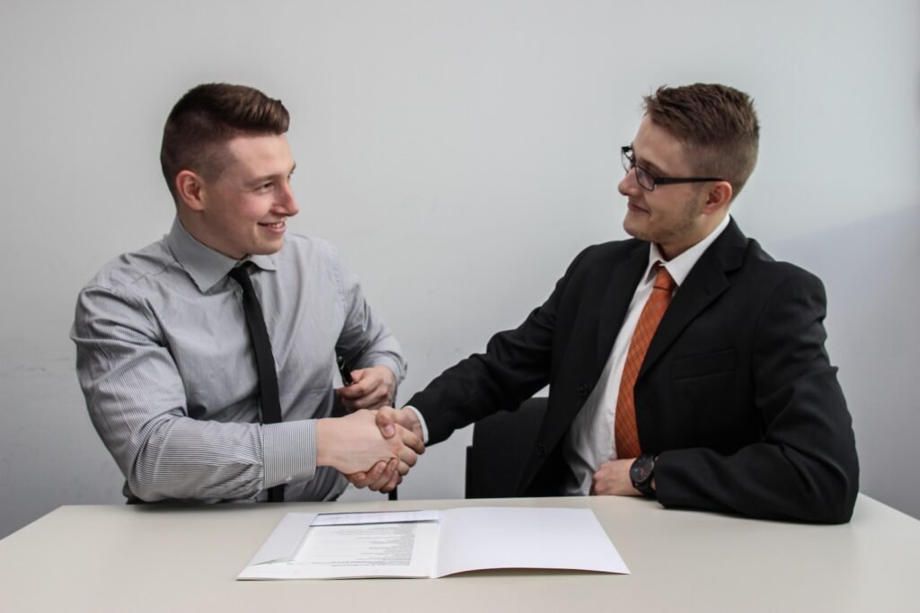 Now Air Conditioining Emergency Air Conditioning and Heating Services. Two men shaking hands at a desk.