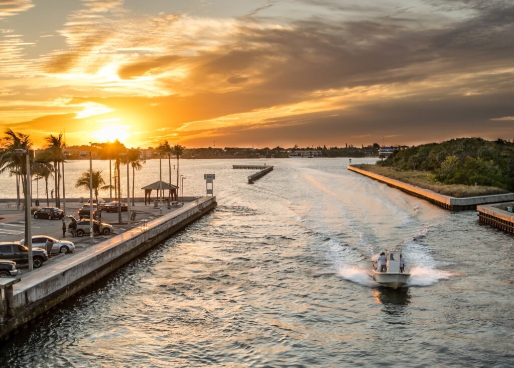 Now Air Conditioining Emergency Air Conditioning and Heating Services. A boat on an inlet with a sunset in the background.